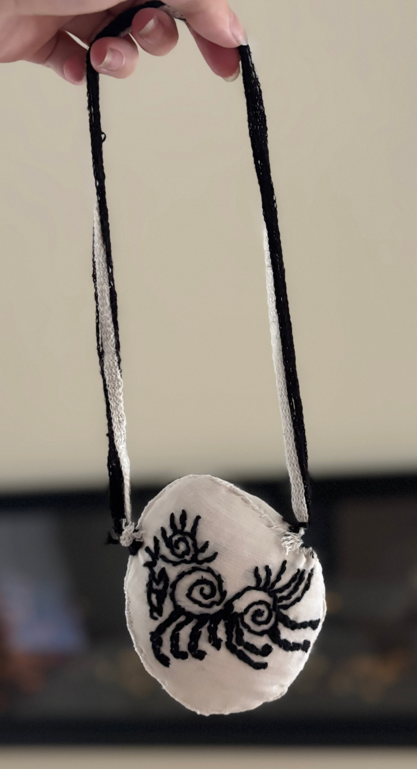 Custom Embroidered Decorative Hanging Art for Doors, Gallery Walls Featuring Sleipnir Norse Mythology In black and white shown held up in front of blurred art piece on interior wall